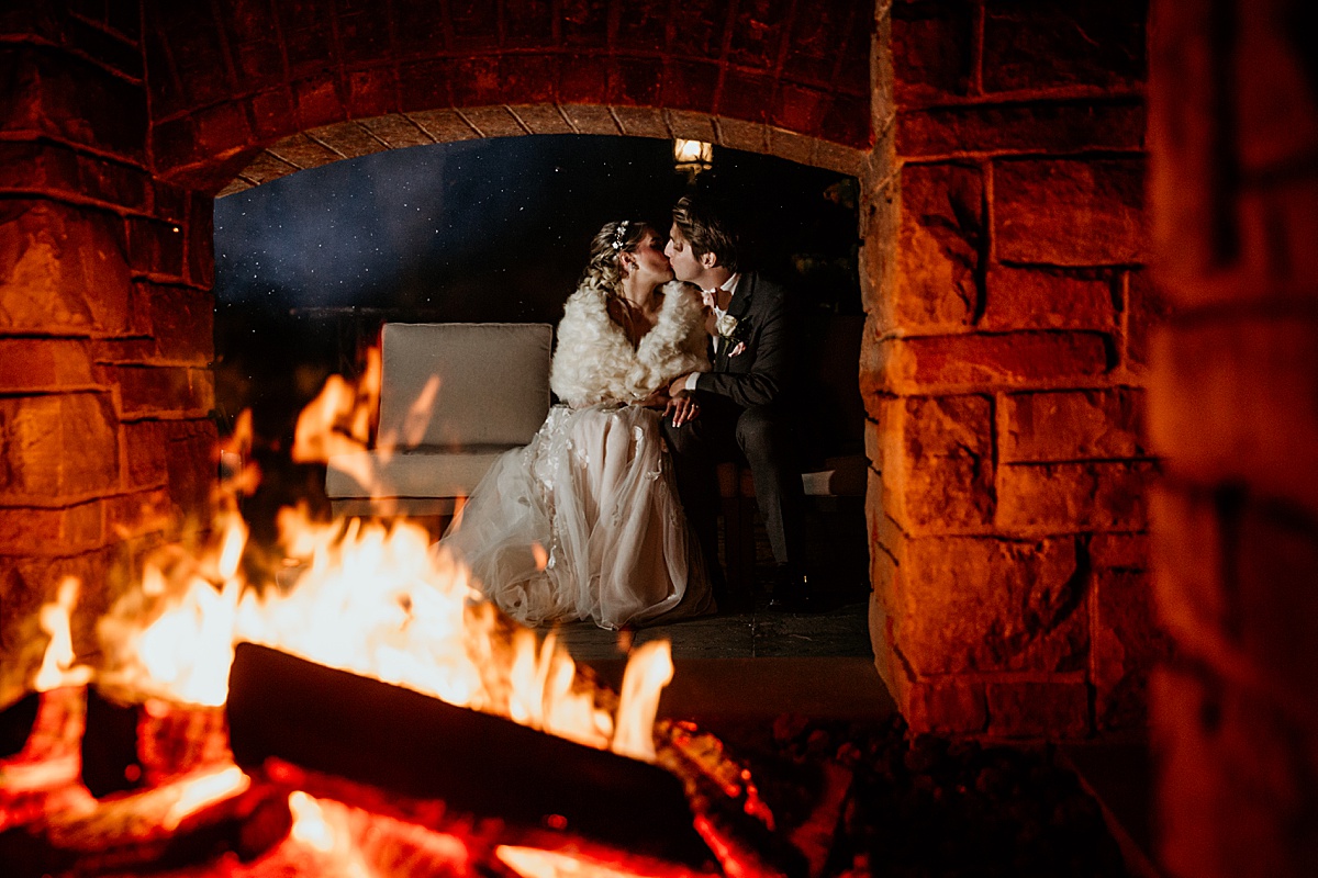 winter-wedding-couple-snuggling-bonfire