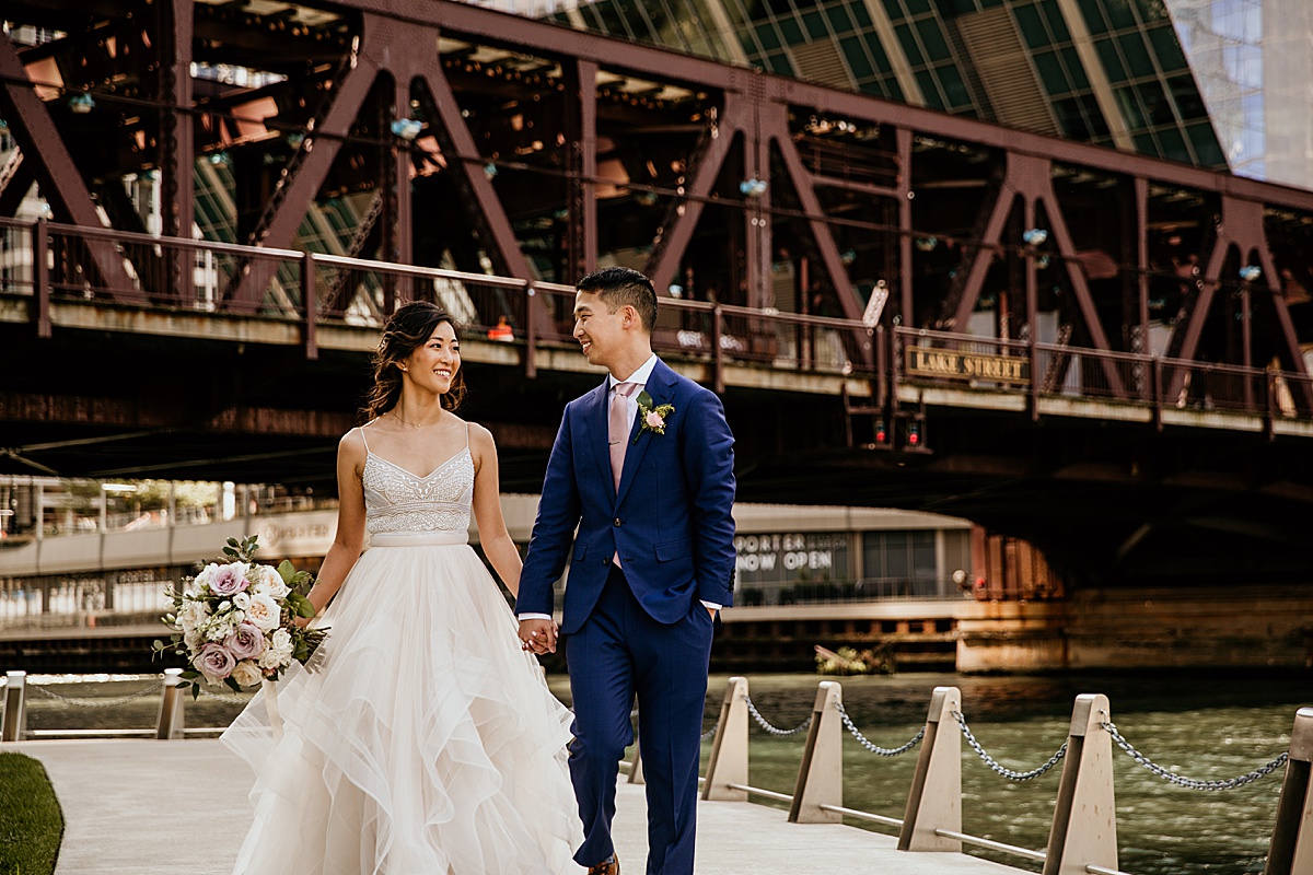 bride and groom walking down the chicago river walk