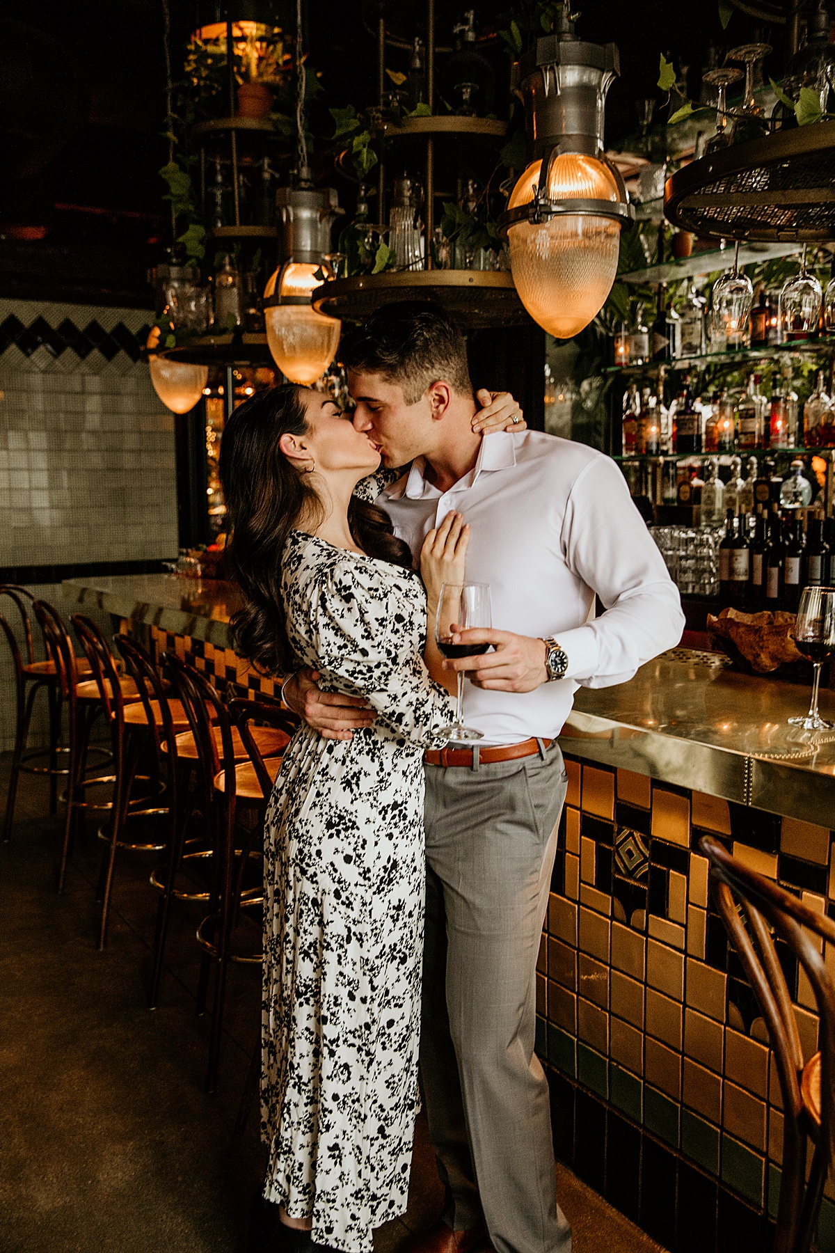 Man and woman kissing at a bar restaurant.