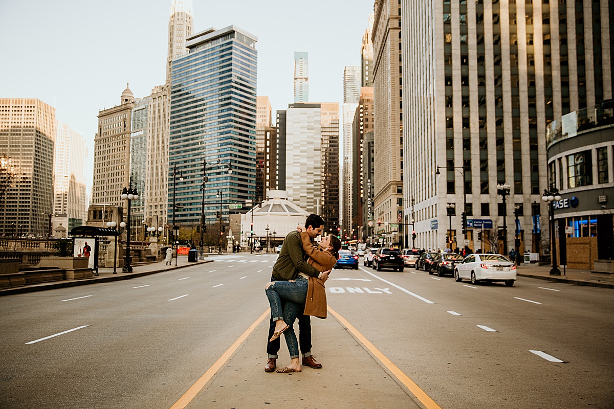 Couple kissing in the middle of Michigan avenue for their chicago engagement photos.