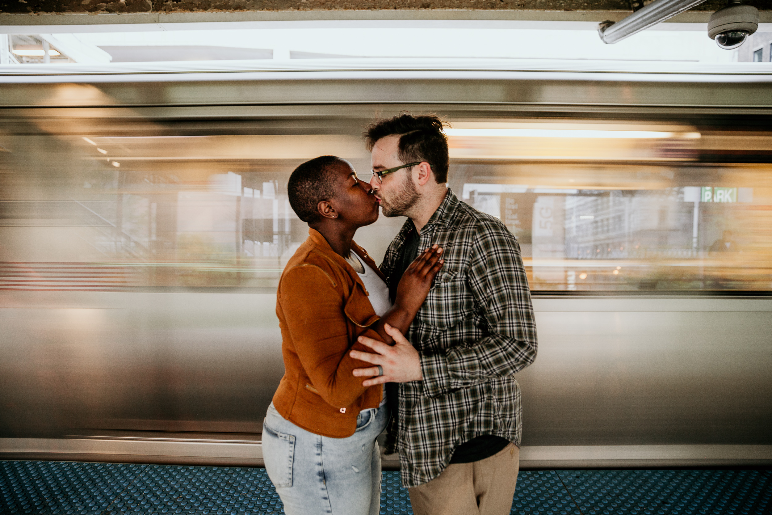 couple kissing in front of a moving train