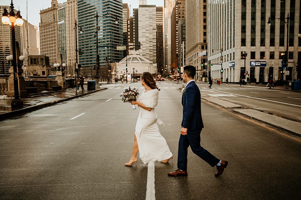 Wedding couple walking in the middle of Michigan Avenue in chicago