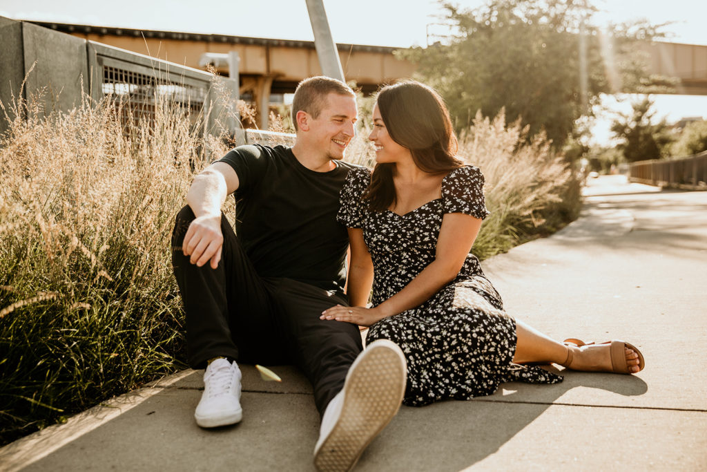 Couple's engagement photos sitting on the 606 trail of chicago