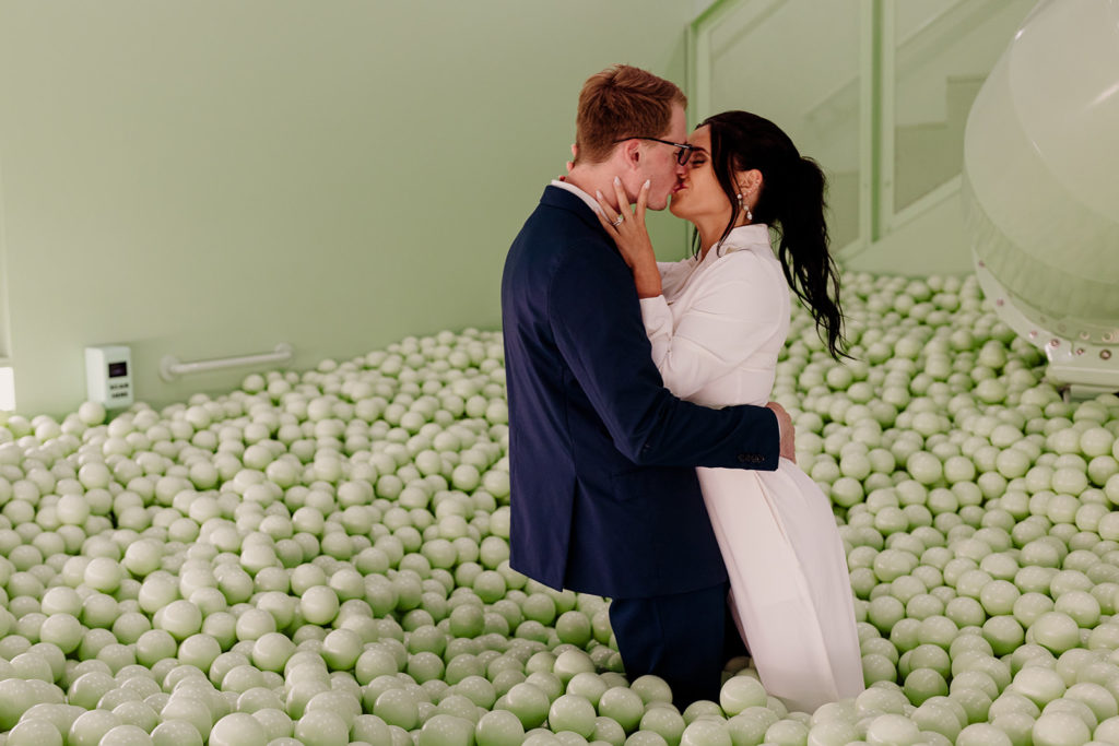 couple playing in ball pit after wedding day at chicago color factory museum 