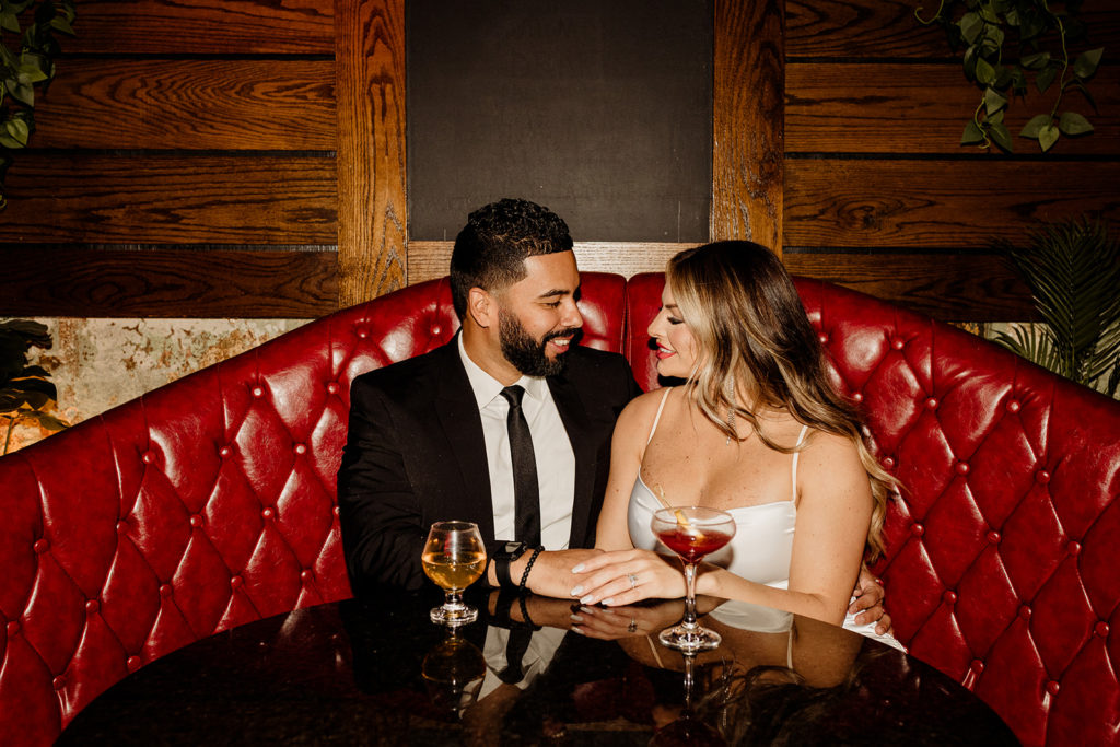 engaged couple having drinks at chicago bar on couch