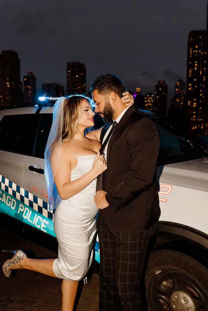 engaged couple in downtown chicago at night with police car