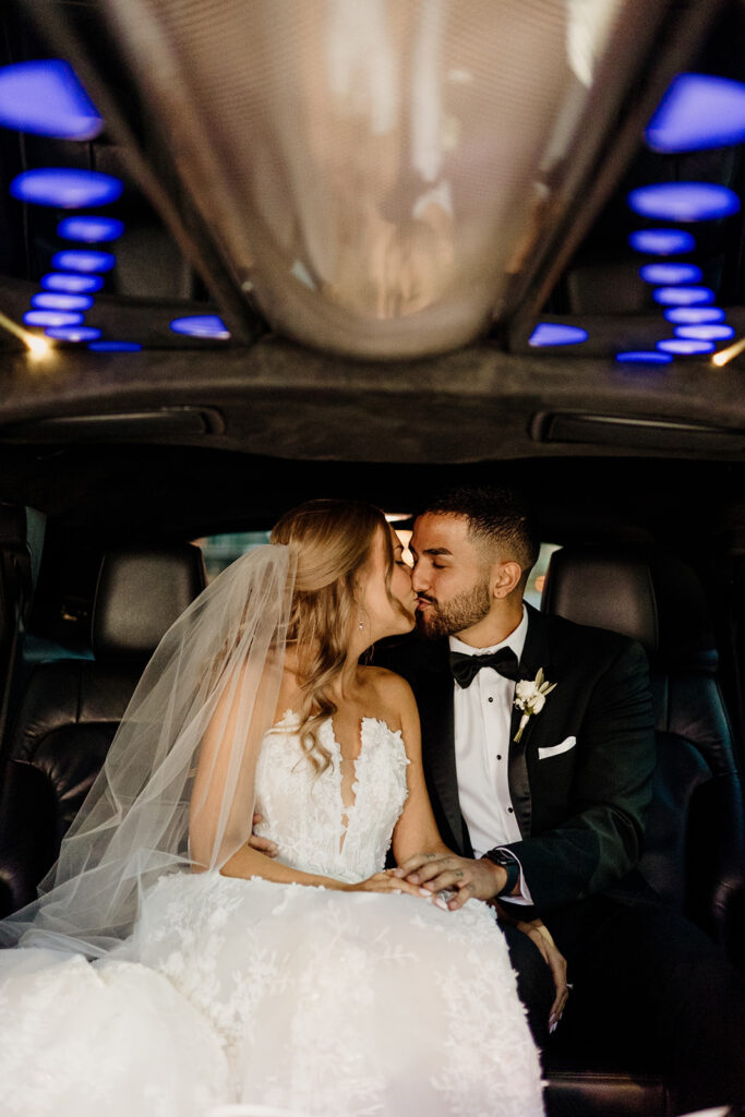 bride and groom kissing in car on morning of wedding day