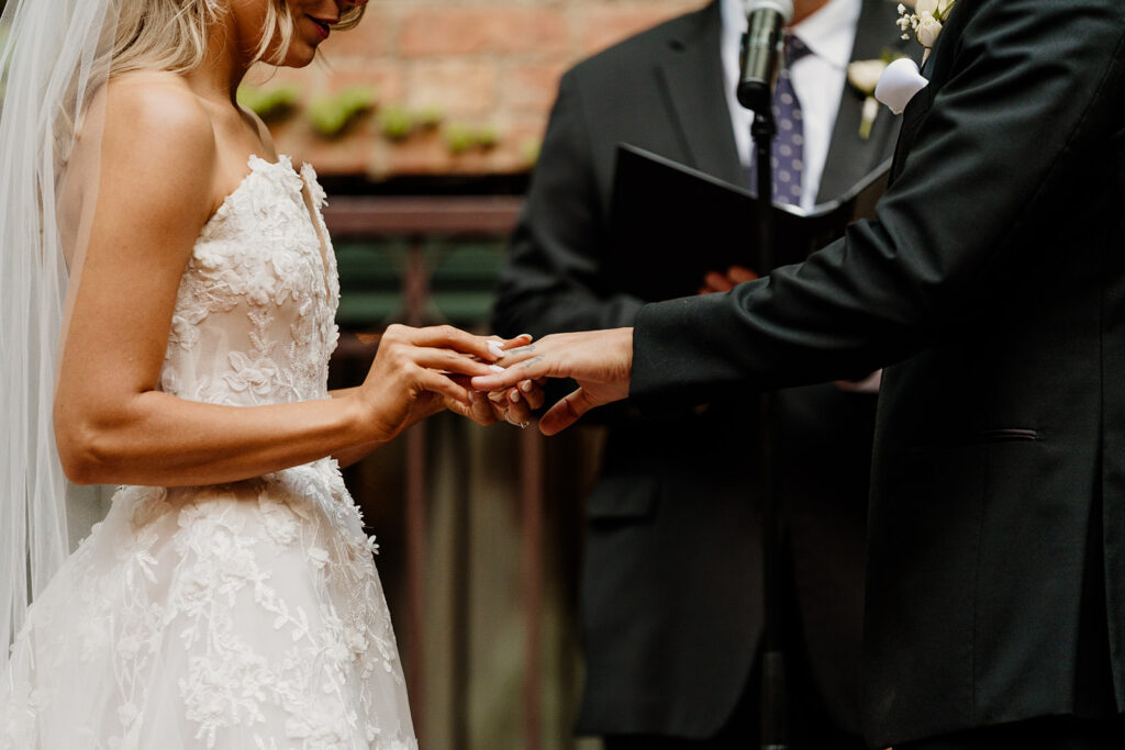 bride and groom exchange rings during wedding ceremony