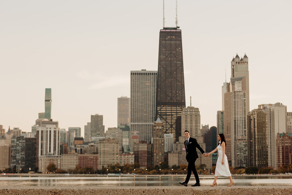 engaged couple walking with chicago skyline