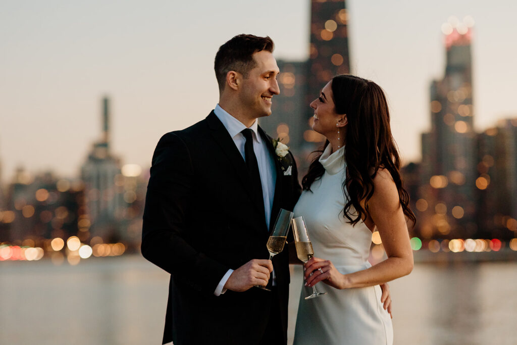engaged couple drinks champagne by chicago skyline