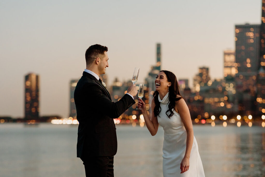 engaged couple cheers champagne by chicago skyline